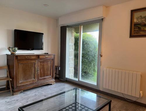 un salon avec une télévision à écran plat et une fenêtre dans l'établissement 656 - Charmant studio à Erquy, situé à environ 100m du centre 300m de la plage, à Erquy