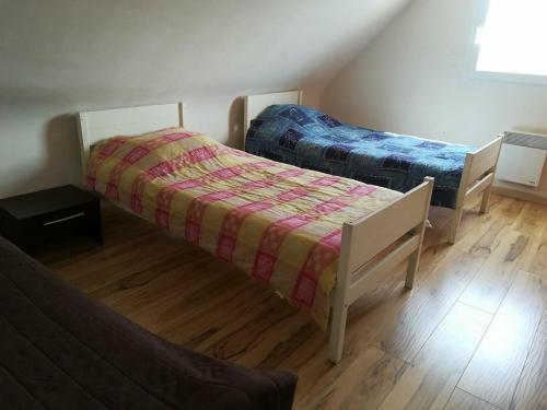 2 łóżka w pokoju z drewnianą podłogą w obiekcie 657 - Belle maison vue mer à Erquy, à 900m du centre et 1km200 de la plage w mieście Erquy