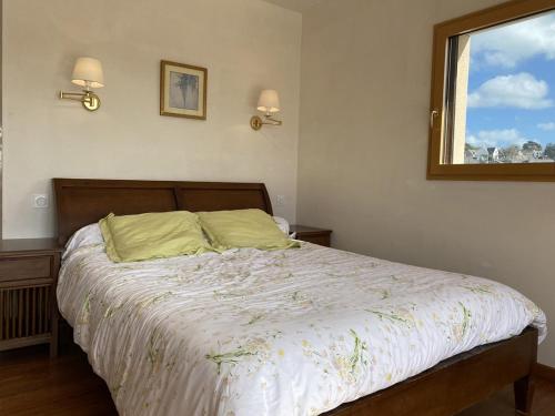 - une chambre avec un lit doté d'une couette blanche et d'une fenêtre dans l'établissement 662 - Grande et Magnifique maison vue mer pour séjour en famille, à Erquy