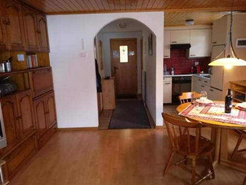een keuken met een tafel en een eetkamer bij 3 12 Zimmer Duplex Ferienwohnung Moosalpe A in Bürchen
