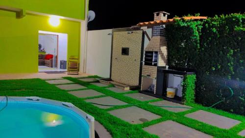 a backyard with a pool and a house at Casa p/ temporada, praia guaibim in Guaibim