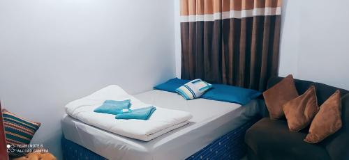 a bed with pillows on it next to a couch at Cantinho da Rota ll in São Roque
