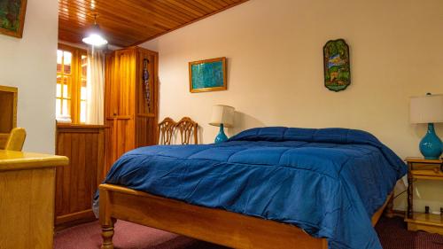 a bedroom with a bed with a blue comforter at Los Quetzales Ecolodge & Spa in Cerro Punta