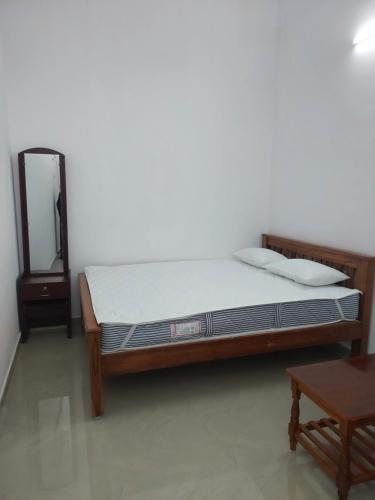 a bedroom with a bed and a table and a mirror at Hill house in Tiruvannāmalai