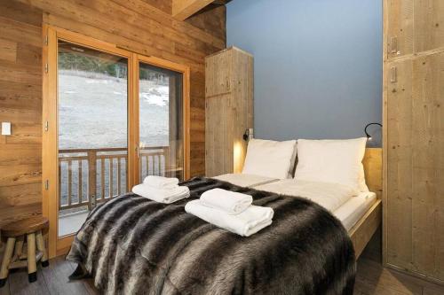 een slaapkamer met een groot bed en handdoeken bij Mont royal - Apt B304 - BO Immobilier in Châtel