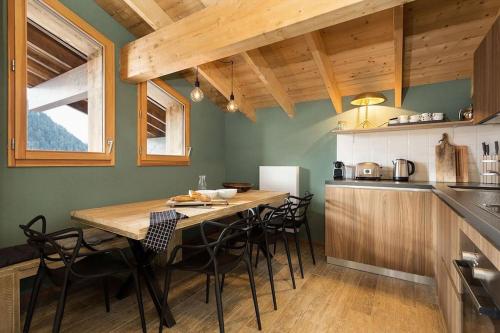 une cuisine avec une table en bois et quelques chaises dans l'établissement Mont royal - Apt B304 - BO Immobilier-Châtel - Multipass été 2025 en option à 3e par jour et par personne, à Châtel