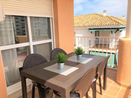 d'un balcon avec une table en bois et des chaises. dans l'établissement Stylish Apartment With Terrace Arroyo De La Miel, à Benalmádena