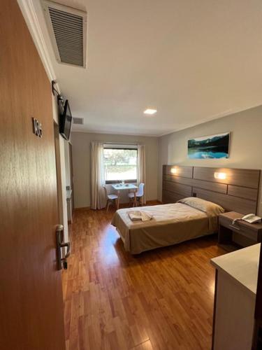 a bedroom with a bed and a table in it at Hotel Rincon Del Este in General Deheza