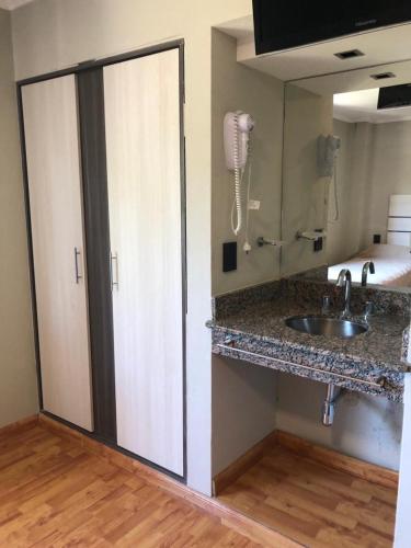 a kitchen with a sink and a phone on the wall at Hotel Rincon Del Este in General Deheza