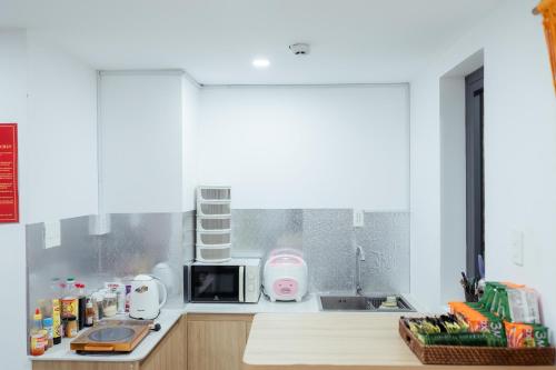 a kitchen with a counter top with a microwave at The Sophia Apartment - Thao Dien Central in Ho Chi Minh City