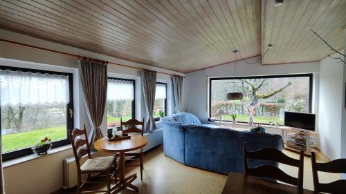 a living room with a blue couch and a table at Sauerland Alm Winterberg 5 in Hallenberg