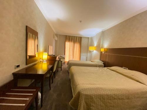 um quarto de hotel com duas camas e uma mesa em Queen Thermal Resort Hotel em Emet