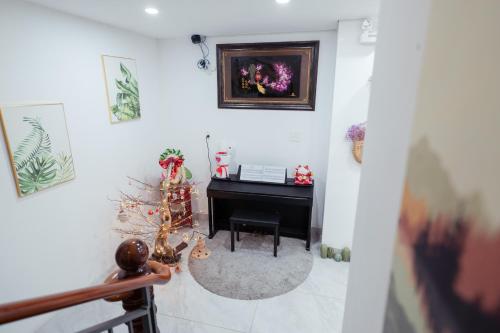 a room with a piano and a christmas tree at The Sophia Apartment - Thao Dien Central in Ho Chi Minh City