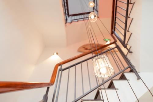 a staircase with a light fixture hanging from the ceiling at The Sophia Apartment - Thao Dien Central in Ho Chi Minh City