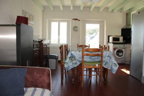 Il comprend une cuisine équipée d'une table et de chaises. dans l'établissement 701 - Maison face à la plage au domaine de LANRUEN, à Erquy, à Le Val