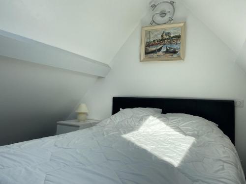 - une chambre avec un lit blanc et une photo sur le mur dans l'établissement 701 - Maison face à la plage au domaine de LANRUEN, à Erquy, à Le Val