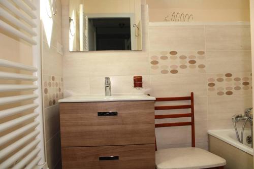 une salle de bain avec un lavabo, un miroir et une chaise dans l'établissement 701 - Maison face à la plage au domaine de LANRUEN, à Erquy, à Le Val