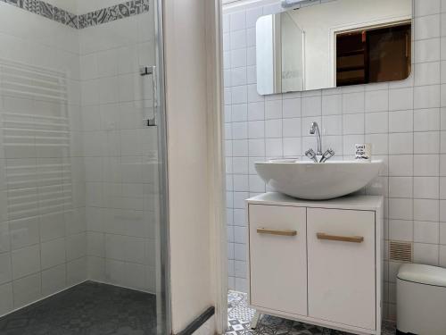 une salle de bain blanche avec un lavabo et une douche dans l'établissement 703 - Charmante maison du Domaine de Lanruen, les pieds dans l'eau, à Erquy