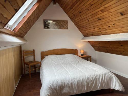 - une chambre avec un lit blanc et un plafond en bois dans l'établissement 703 - Charmante maison du Domaine de Lanruen, les pieds dans l'eau, à Erquy