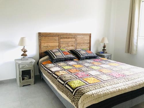 une chambre avec un grand lit avec deux tables de nuit dans l'établissement Appartement Les terrasses Calvi, à Calvi