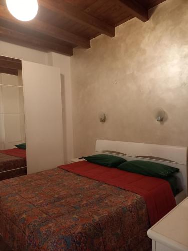 バーリにあるTrulli&CaseFichiのベッドルーム1室(赤と緑の毛布付きのベッド1台付)