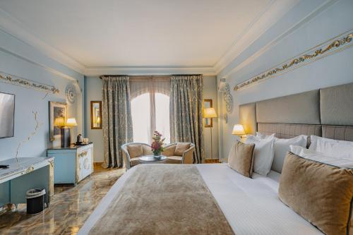 una camera d'albergo con un grande letto e una finestra di Grand Mogador Menara & Spa a Marrakech