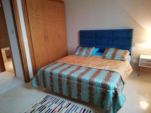 una camera con letto e testiera blu di appartement florence a Tunisi
