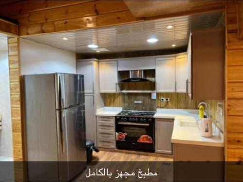 a kitchen with a stainless steel refrigerator and a stove at القصر الريفي in Al Khafji