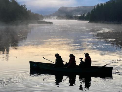a group of people in a boat on a river at ElveRo Lodge in Trysil