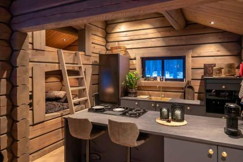 a kitchen with wooden walls and a counter with a stove at ElveRo Lodge in Trysil
