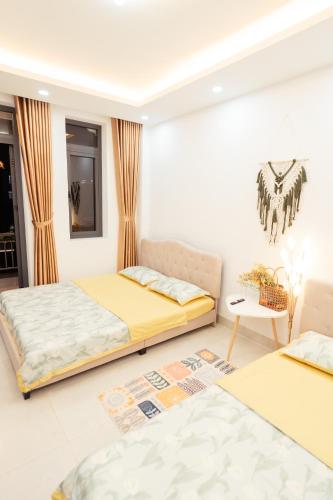 a bedroom with two beds and a table at The Sophia Apartment - Thao Dien Central in Ho Chi Minh City