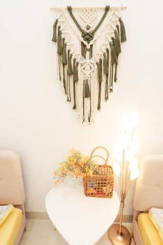 a necklace hanging on a wall next to a table at The Sophia Apartment - Thao Dien Central in Ho Chi Minh City