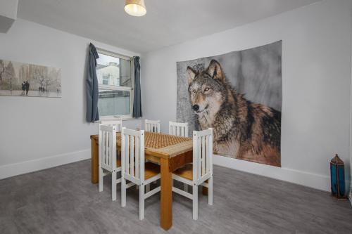 a dining room with a wolf painting on the wall at Beautiful Family Home in Blackpool for you in Blackpool