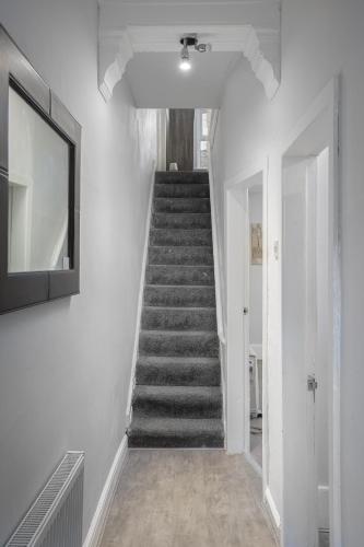 a staircase in a white room with a stair case at Beautiful Family Home in Blackpool for you in Blackpool