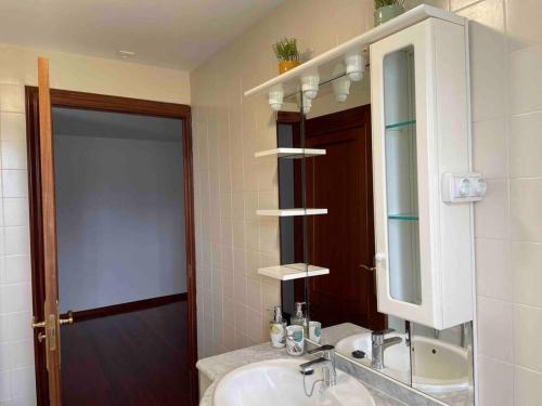 La salle de bains est pourvue d'un lavabo et d'un miroir. dans l'établissement A casa de Lago, à Lago