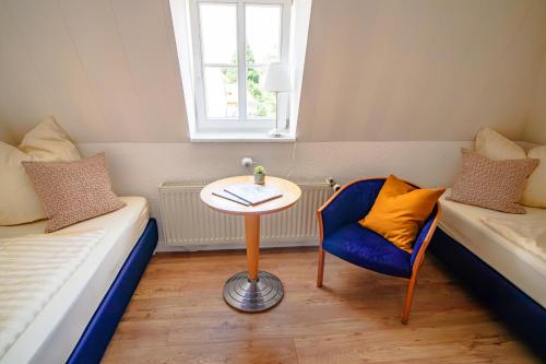 um quarto com uma mesa, uma cadeira e uma cama em Harzträume No1 & 2 Doppelwohnung em Wernigerode