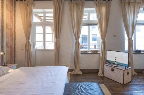 a bedroom with a bed and a flat screen tv at Lodge am Oxenweg - Zimmer 2 in Husum