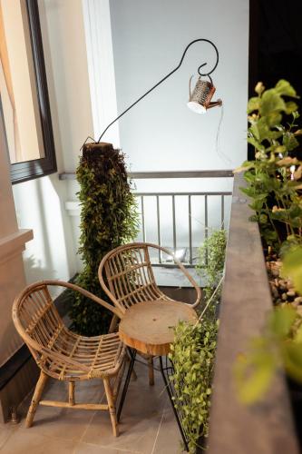 two chairs and a table on a balcony with plants at The Sophia Apartment - Thao Dien Central in Ho Chi Minh City