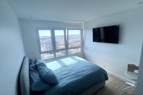 une chambre avec un lit et une télévision à écran plat dans l'établissement Nice Apartment with amazing view of Paris + Parking, à Paris