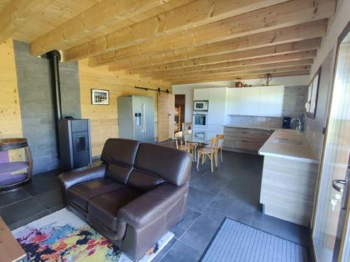 sala de estar con sofá de cuero y cocina en Svea Lodge, en Thollon-les-Mémises