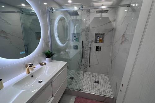 une salle de bain blanche avec un lavabo et une douche dans l'établissement Nice Apartment with amazing view of Paris + Parking, à Paris