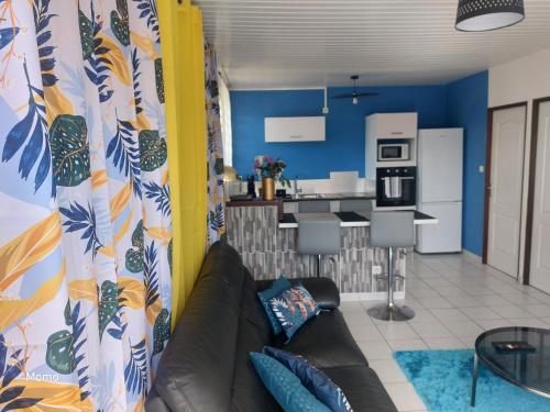 a living room with a couch and a kitchen at Turquoise in Cayenne