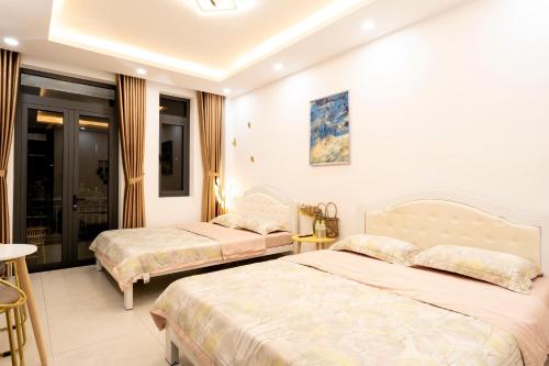 a hotel room with two beds and a balcony at The Sophia Apartment - Thao Dien Central in Ho Chi Minh City
