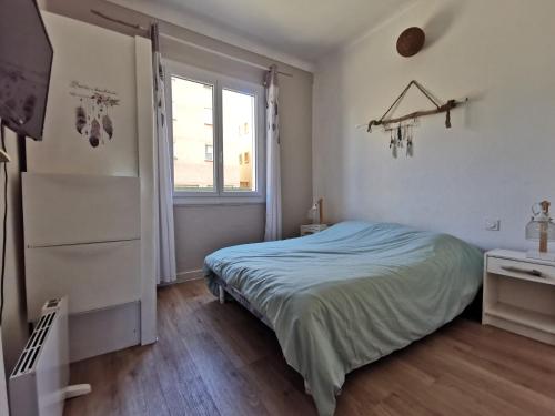 une chambre blanche avec un lit et une fenêtre dans l'établissement T3 avec terrasse à 200 mètres de la mer, à Canet