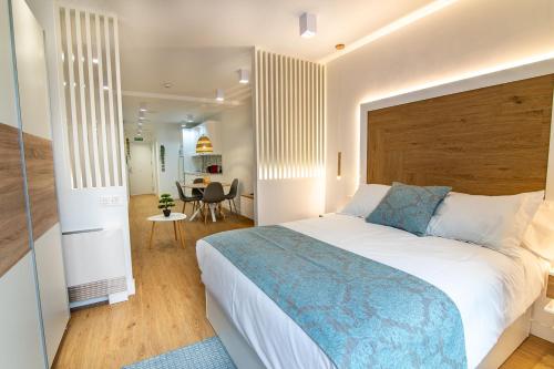 バルデペニャスにあるMQ Suites Veronicaのベッドルーム1室(大型ベッド1台付)、ダイニングルームが備わります。