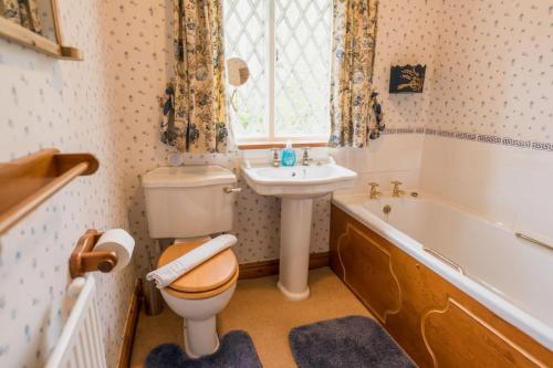 a bathroom with a toilet and a sink and a tub at Traditional English country 4 bed cottage near Chester - For 7 people in Pulford