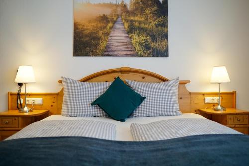 1 dormitorio con 1 cama con almohadas azules y blancas en HoFer am Zeitberg Ferienwohnung Lichtenbach, en Bad Kohlgrub