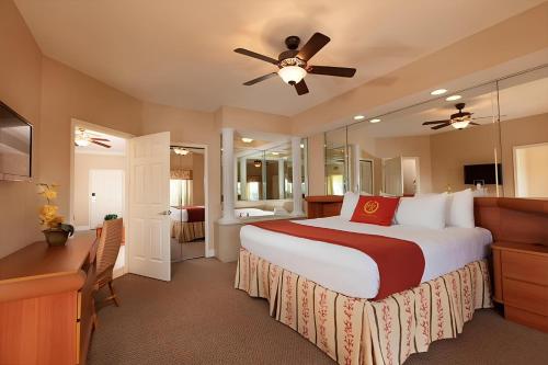 Westgate Town Resort في أورلاندو: غرفة نوم بسرير كبير ومروحة سقف