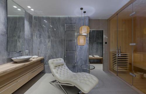 a bathroom with a sink and a shower and a chair at Artisan's House in Sitia