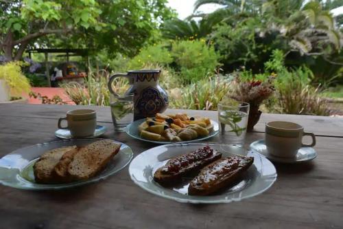 a table with two plates of food and coffee cups at La Casona de Aime, Habitaciones privadas con Desayuno in Punta del Este